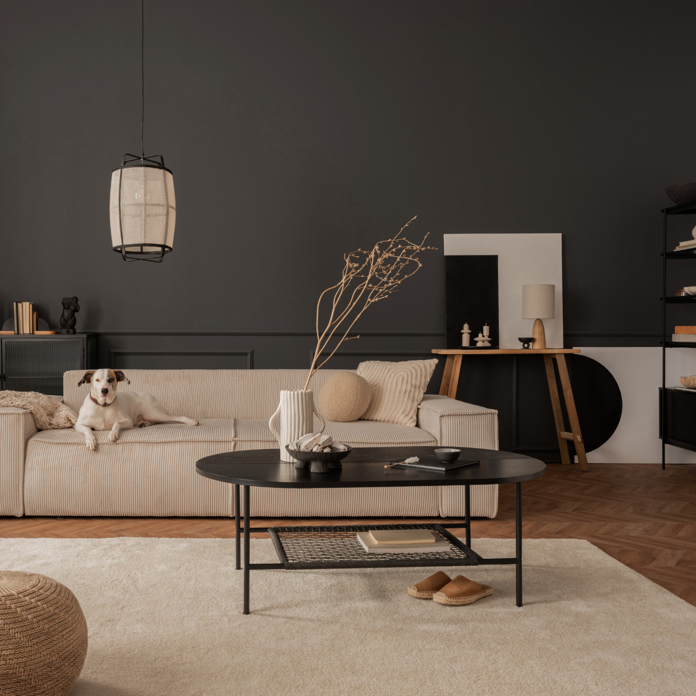 Charcoal-walled living room with a cord sofa, oval coffee table and pendant light