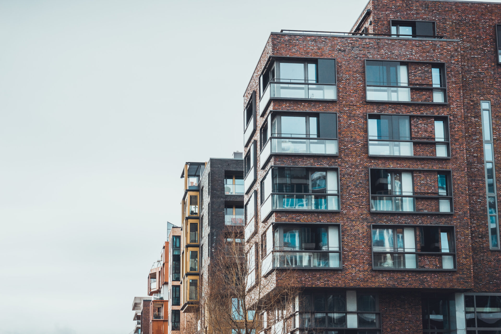 Modern red-brick apartment buildings with balconies and large windows