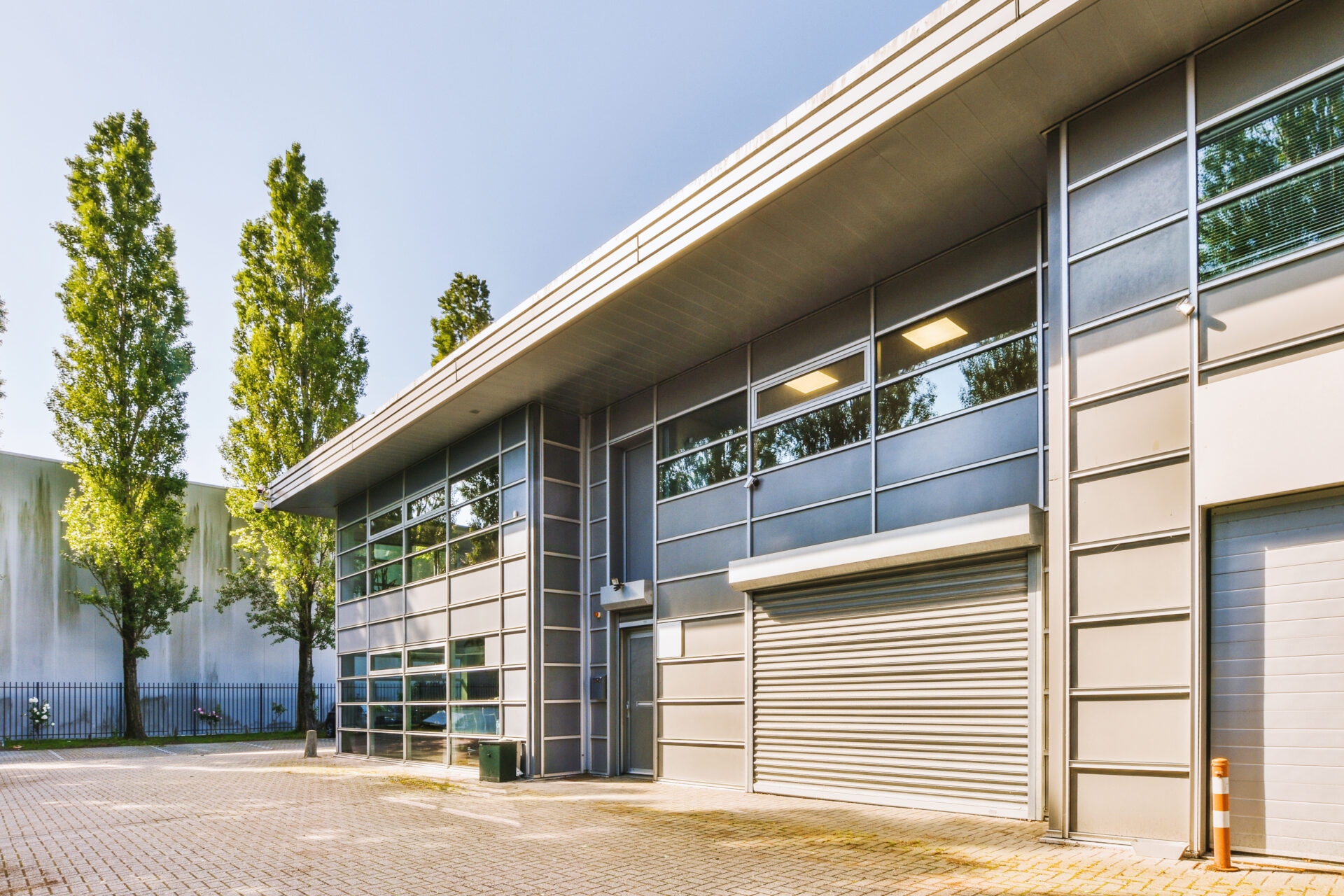 Modern commercial building with glazed panels and roller shutter entrances